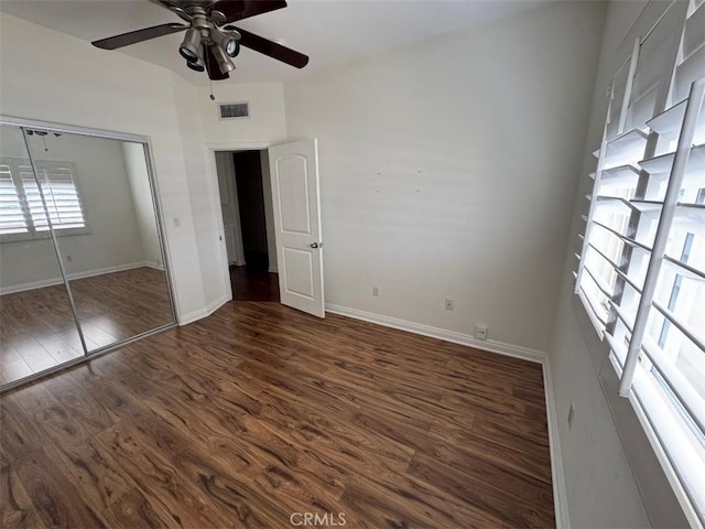 unfurnished bedroom featuring a closet, visible vents, wood finished floors, and baseboards