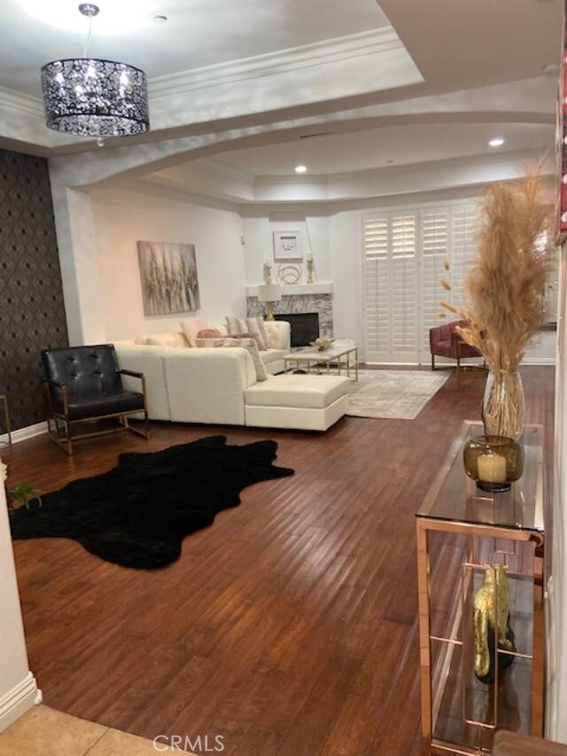 14535 Margate St Unit 12, Sherman Oaks, CA 91411 - living room with a raised ceiling, wood finished floors, crown molding, wallpapered walls, and a fireplace