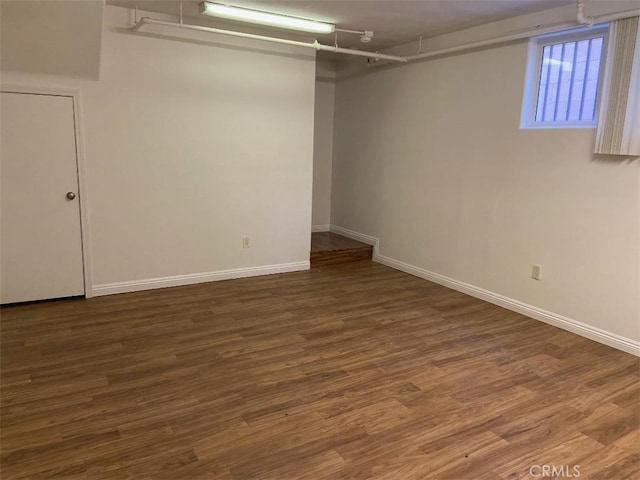 below grade area featuring baseboards and wood finished floors