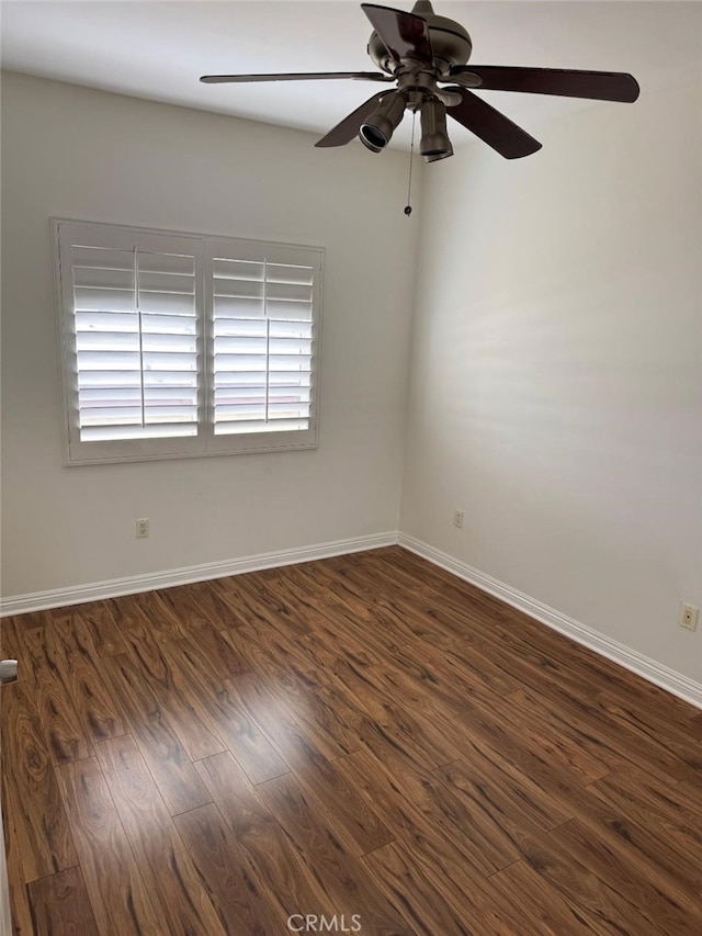 unfurnished room featuring baseboards, dark wood finished floors, and ceiling fan