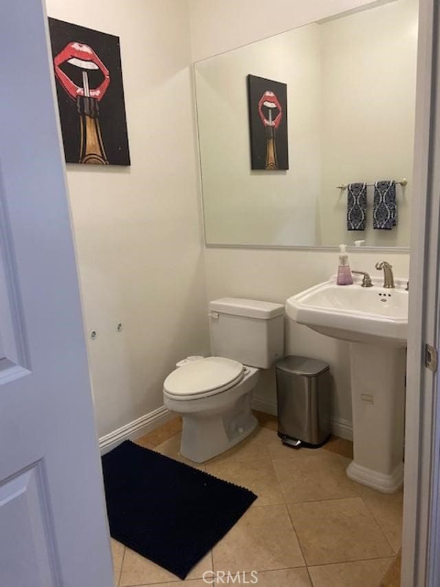 bathroom featuring toilet, baseboards, and tile patterned floors