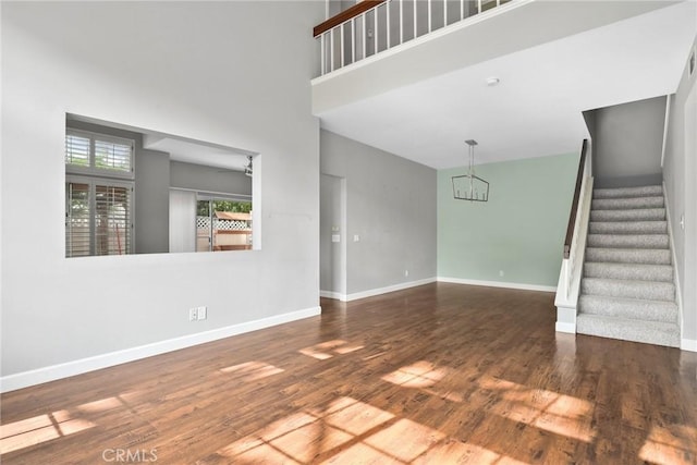1092 Amberton Ln, Newbury Park, CA 91320 - unfurnished living room featuring a chandelier, stairs, wood finished floors, baseboards, and a high ceiling
