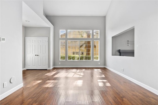 1092 Amberton Ln, Newbury Park, CA 91320 - unfurnished living room featuring baseboards, wood finished floors, and a high ceiling