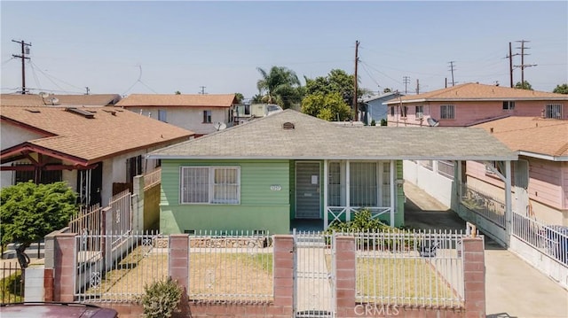 1257 E 76th Pl, Los Angeles, CA 90001 - view of front facade with a fenced front yard, a gate, a shingled roof, and a porch