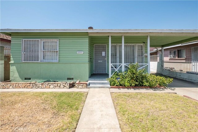 1257 E 76th Pl, Los Angeles, CA 90001 - view of front of property with a front lawn, covered porch, and crawl space