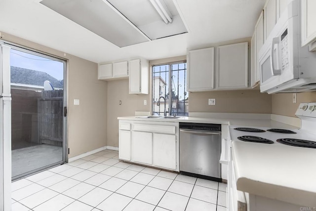 kitchen with a sink, white appliances, white cabinetry, light countertops, and light tile patterned floors