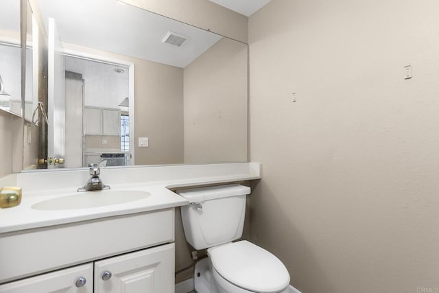 bathroom featuring vanity, toilet, and visible vents