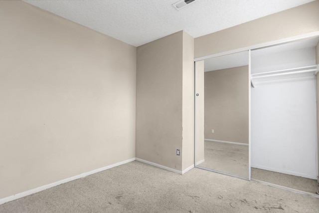 unfurnished bedroom with a closet, visible vents, baseboards, and carpet floors