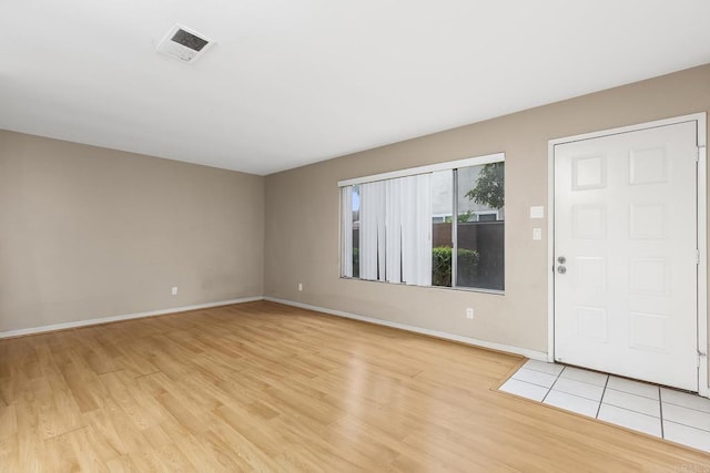 interior space with light wood-style floors, visible vents, and baseboards