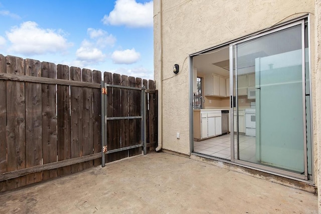 view of patio featuring fence and a sink