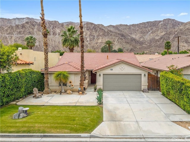 51565 Avenida Carranza Ln, Quinta, CA 92253 - mediterranean / spanish home with an attached garage, stucco siding, driveway, a tile roof, and a mountain view