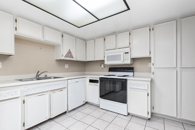 kitchen with light countertops, light tile patterned floors, a sink, and white appliances