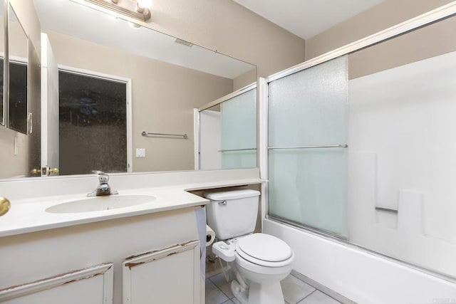 full bath featuring bath / shower combo with glass door, tile patterned floors, vanity, and toilet