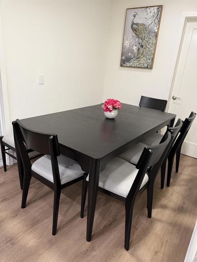 dining area with light wood-style floors and baseboards
