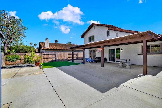 back of property featuring fence, a patio, stucco siding, a tiled roof, and a chimney