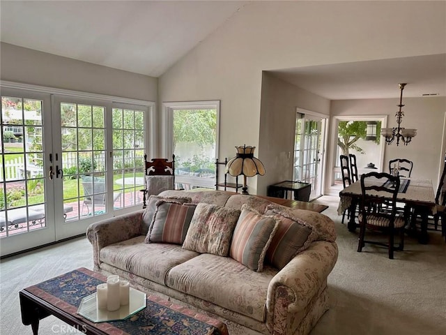 living area featuring a wealth of natural light, a notable chandelier, french doors, and light colored carpet