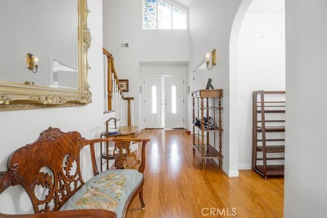 32182 Links Pointe, Laguna Niguel, CA 92677 - entrance foyer featuring arched walkways, wood finished floors, a towering ceiling, stairway, and baseboards