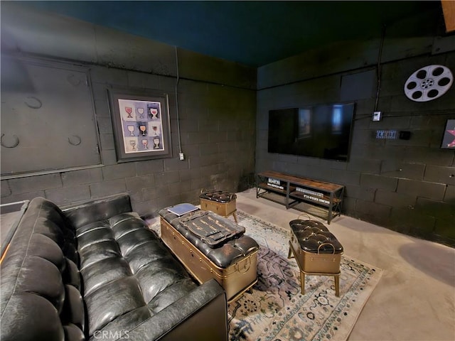 home theater room with concrete floors and concrete block wall