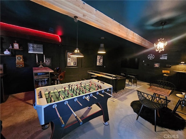 recreation room with finished concrete floors and a notable chandelier
