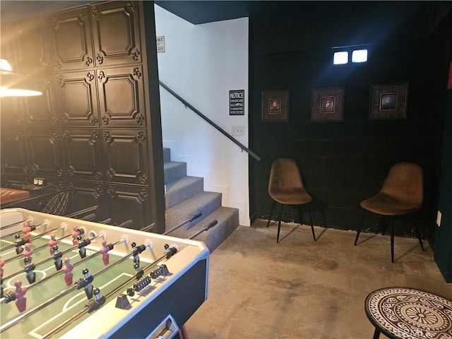 recreation room featuring unfinished concrete flooring