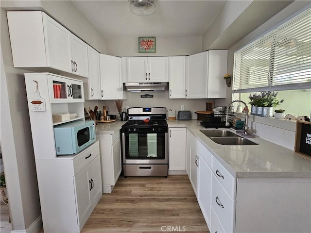 kitchen featuring a sink, white cabinets, gas range, white microwave, and under cabinet range hood
