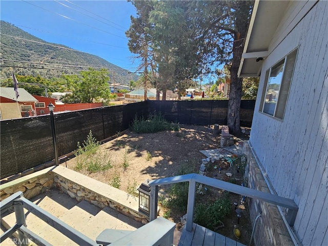 view of yard featuring a mountain view and a fenced backyard