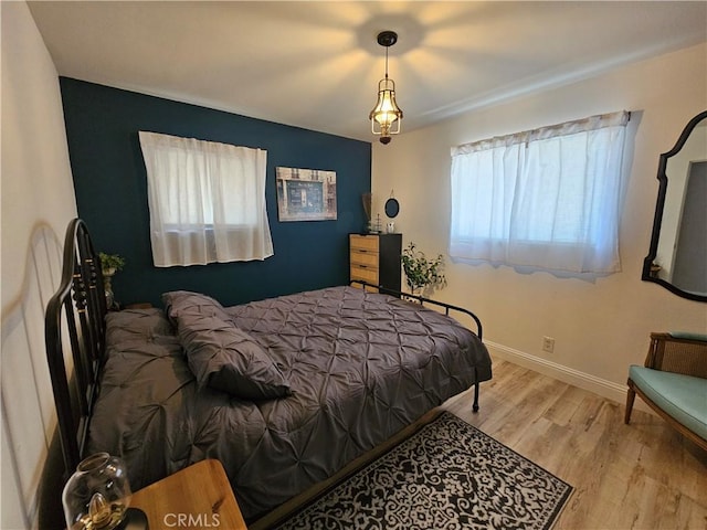bedroom with baseboards and wood finished floors