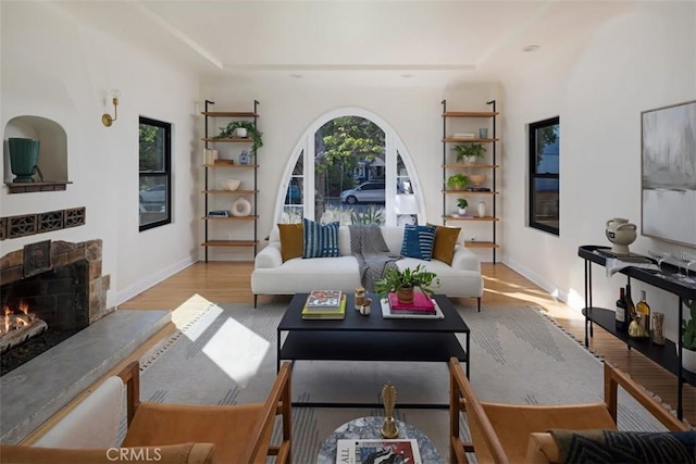 312 W Lutge Ave, Burbank, CA 91506 - living room featuring baseboards, a stone fireplace, a tray ceiling, and wood finished floors