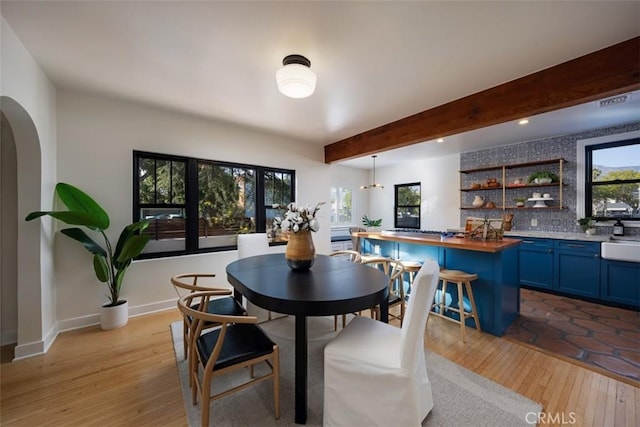 312 W Lutge Ave, Burbank, CA 91506 - dining space featuring light wood finished floors, arched walkways, and beam ceiling