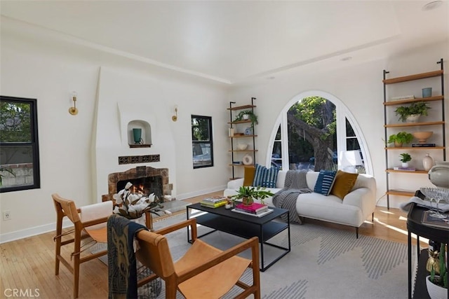 312 W Lutge Ave, Burbank, CA 91506 - living area with light wood-type flooring, a lit fireplace, baseboards, and a raised ceiling
