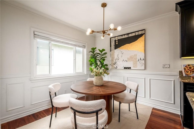 dining area featuring a decorative wall, an inviting chandelier, dark wood-style flooring, and ornamental molding