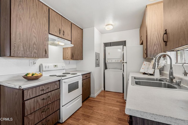 229 S Ventura Rd Unit 105, Port Hueneme, CA 93041 - kitchen featuring white appliances, under cabinet range hood, estacked washer and dryer, a sink, and light countertops