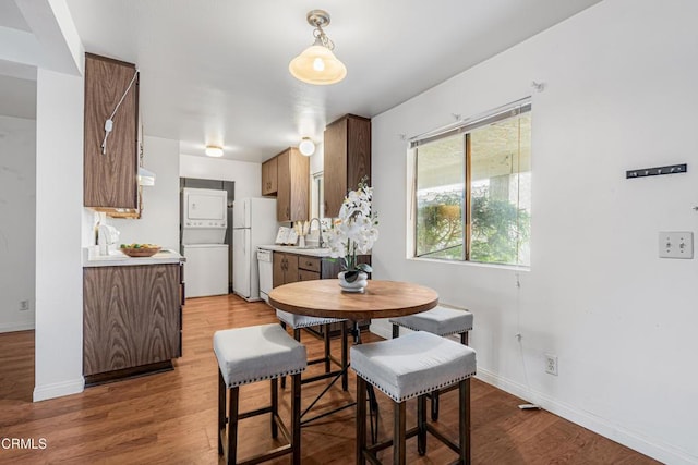 229 S Ventura Rd Unit 105, Port Hueneme, CA 93041 - dining area featuring estacked washer and dryer, wood finished floors, and baseboards