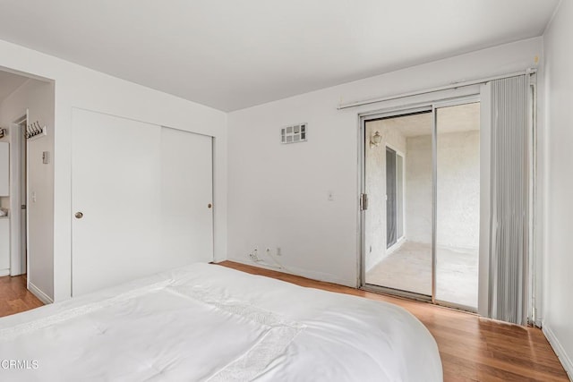 229 S Ventura Rd Unit 105, Port Hueneme, CA 93041 - bedroom featuring access to outside, wood finished floors, a closet, and baseboards