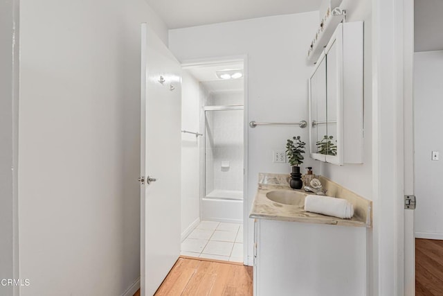 229 S Ventura Rd Unit 105, Port Hueneme, CA 93041 - bathroom featuring vanity, wood finished floors, enclosed tub / shower combo, and baseboards