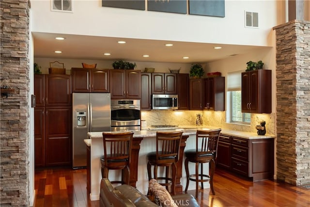 kitchen featuring stainless steel appliances, dark wood-style floors, and visible vents