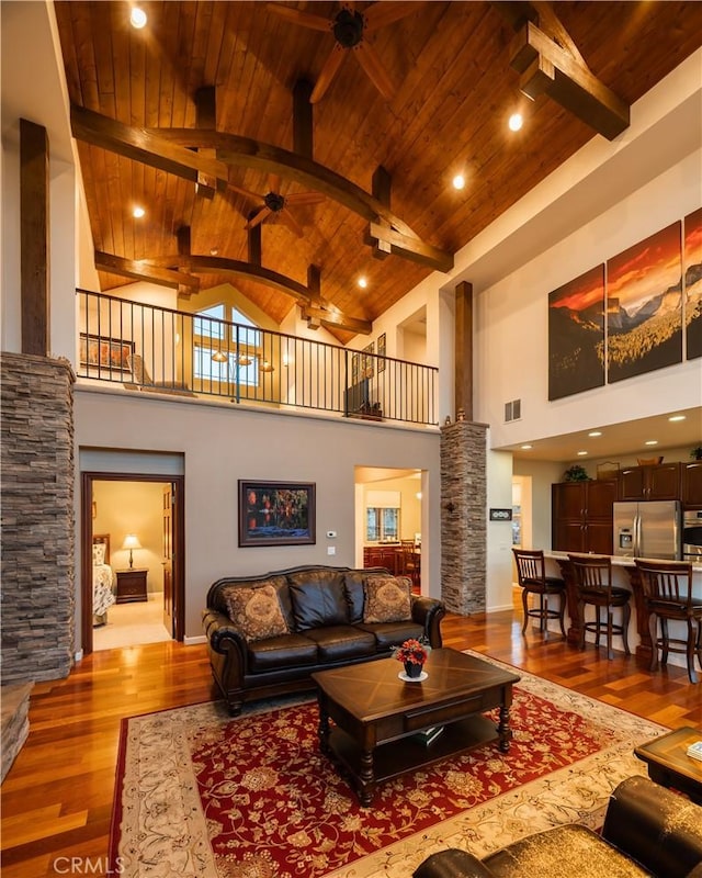 living room with wood finished floors, ornate columns, high vaulted ceiling, wooden ceiling, and a ceiling fan
