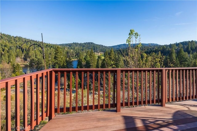 deck with a water view and a forest view