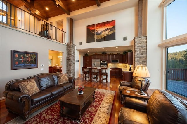 living room with wood ceiling, dark wood-style flooring, ornate columns, and a high ceiling