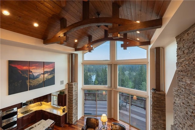 interior space featuring wooden ceiling, beamed ceiling, high vaulted ceiling, and wood finished floors