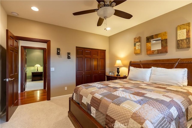 carpeted bedroom with a closet, baseboards, and a ceiling fan