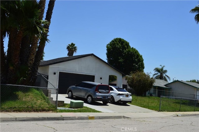 1565 Villa Ct, Highland, CA 92346 - view of front of house featuring a garage, driveway, fence, and stucco siding
