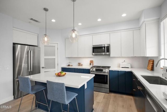 1323 Bayside Cir, Oxnard, CA 93035 - kitchen featuring appliances with stainless steel finishes, a sink, light wood-type flooring, a kitchen breakfast bar, and recessed lighting