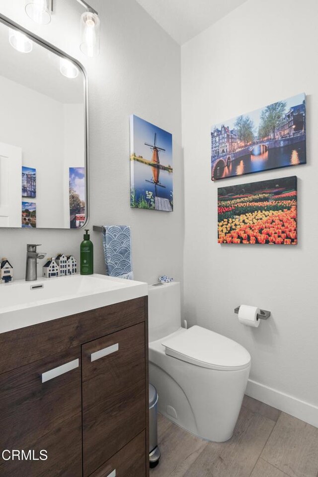 1323 Bayside Cir, Oxnard, CA 93035 - half bath featuring vanity, toilet, wood finished floors, and baseboards
