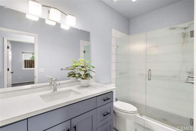 full bathroom with a stall shower, vanity, and toilet
