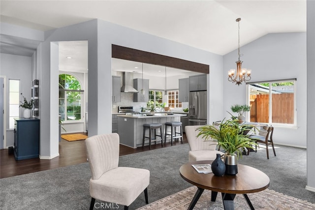 living room featuring lofted ceiling, a notable chandelier, baseboards, and a healthy amount of sunlight