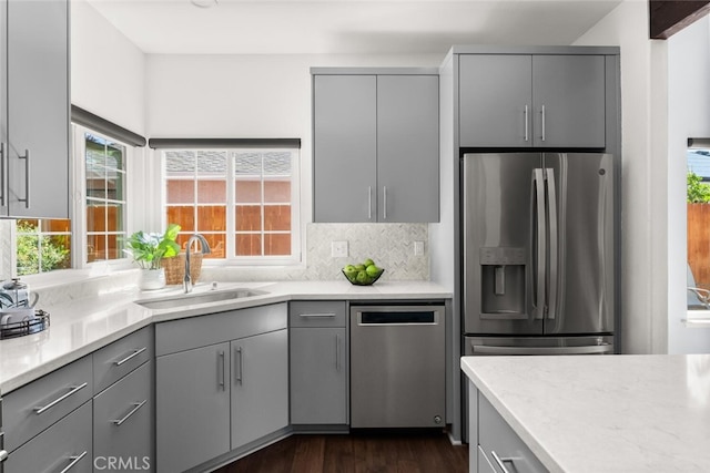 kitchen featuring gray cabinetry, appliances with stainless steel finishes, dark wood-type flooring, and a sink