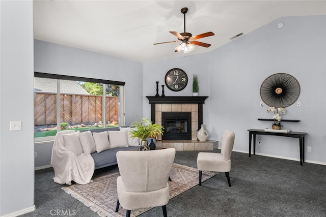 living room featuring a ceiling fan, carpet, visible vents, vaulted ceiling, and a tile fireplace