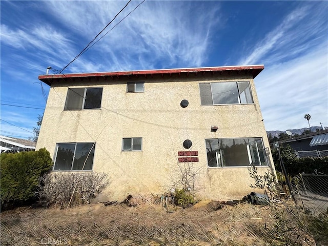 view of side of property with fence and stucco siding