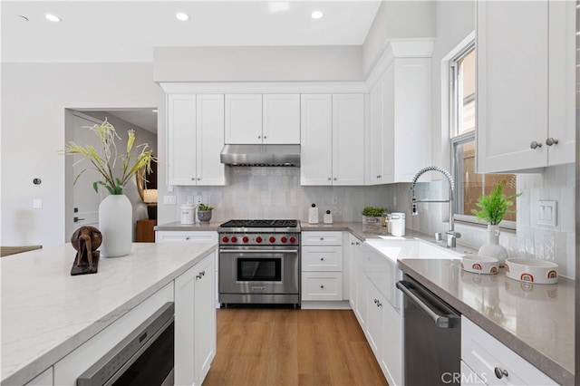 149 Fairgreen, Irvine, CA 92618 - kitchen featuring appliances with stainless steel finishes, under cabinet range hood, a sink, light stone counters, and backsplash